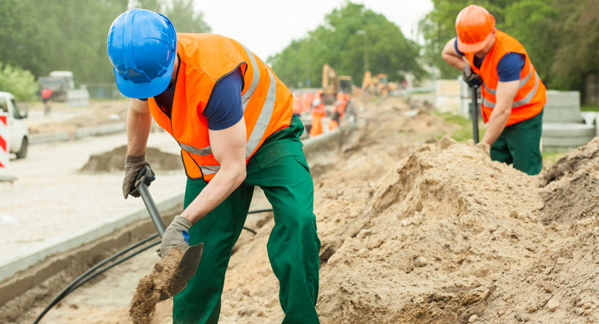 Construction workers digging fiber internet ditch